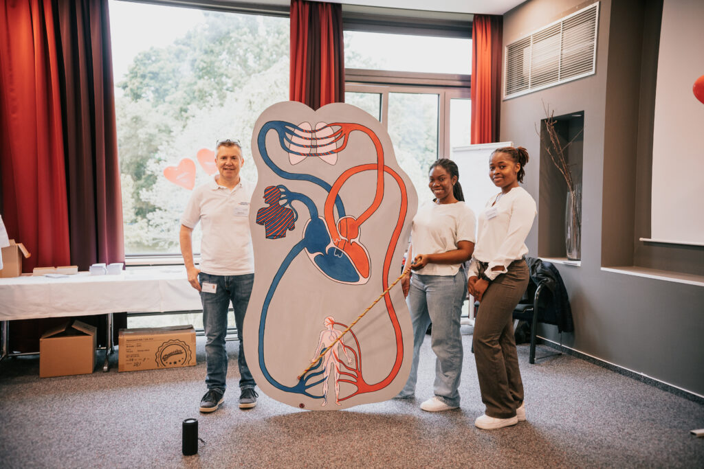 Team der Universität Freiburg steht vor Bild mit Herz und seinem System