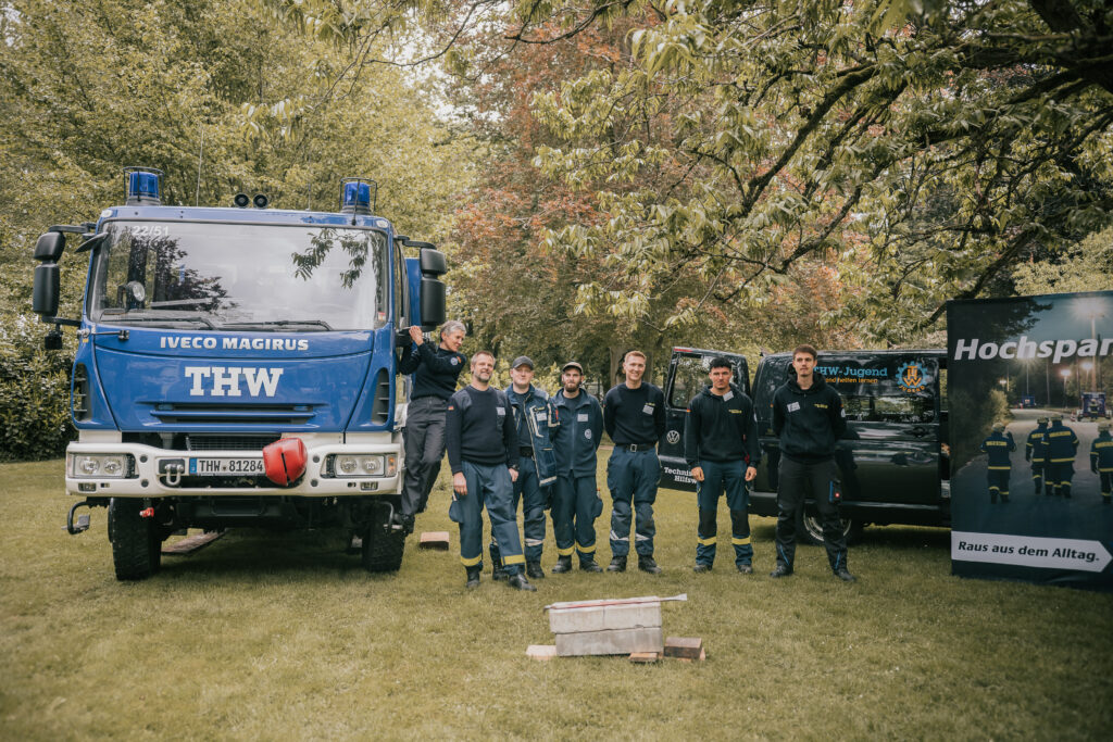 Mitarbeiter stehen vor Stand des THW